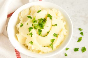 Mashed potatoes with parsley in white bowl
